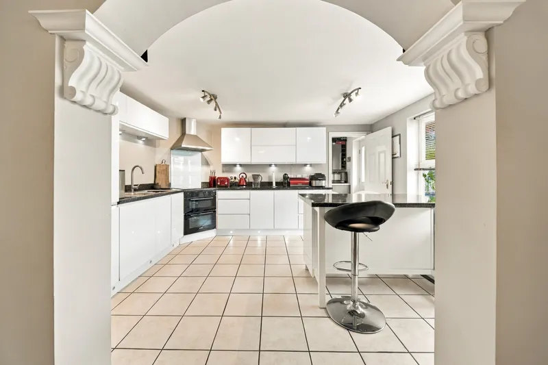 Kitchen with white cabinetry and breakfast bar