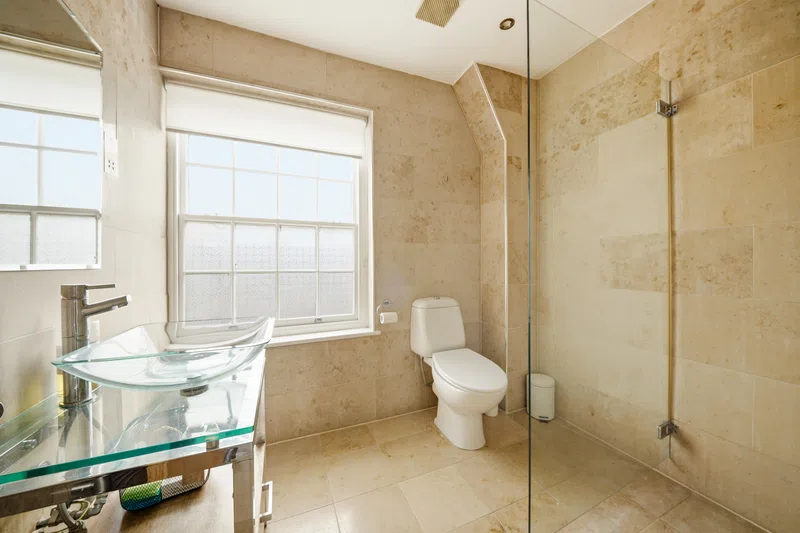 Southampton ensuite bathroom with glass shower and neutral stone finish