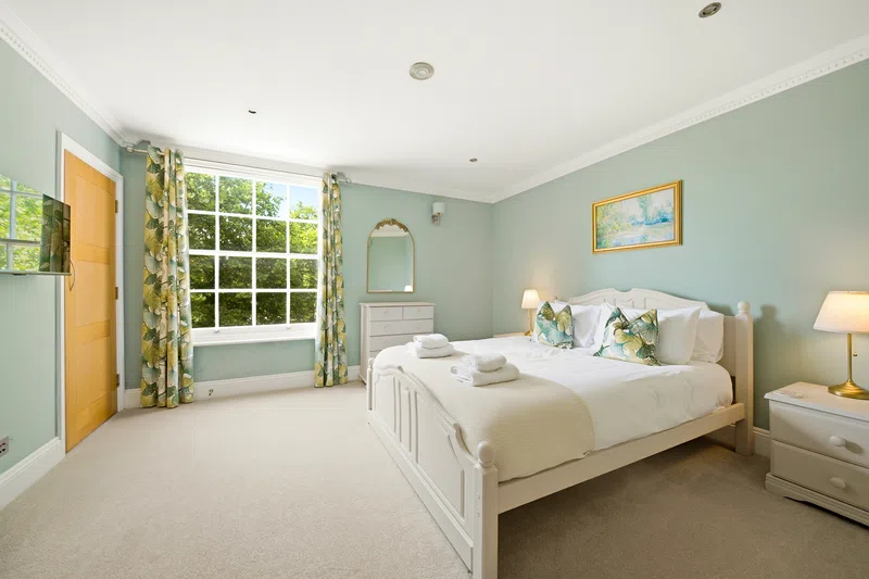 Southampton bedroom with green decor and bright window light