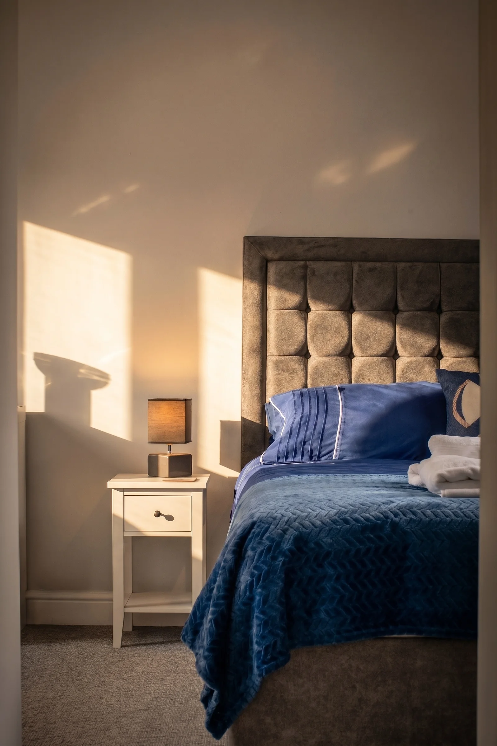 Stylised blue bedroom photographed to show finish, light and spatial detail