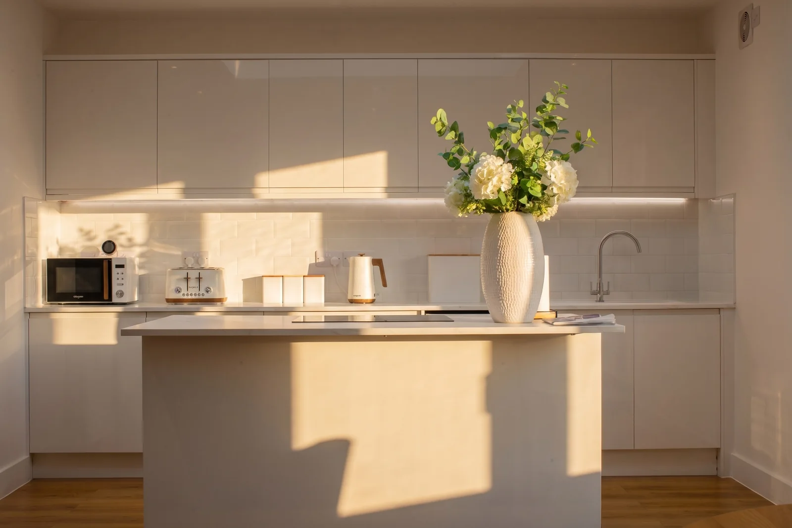 Stylised white kitchen suitable for a direct-booking website hero